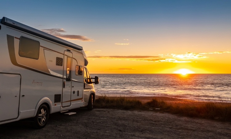 A Burstner TD736 motorhome parked up by the beach with a sunset view