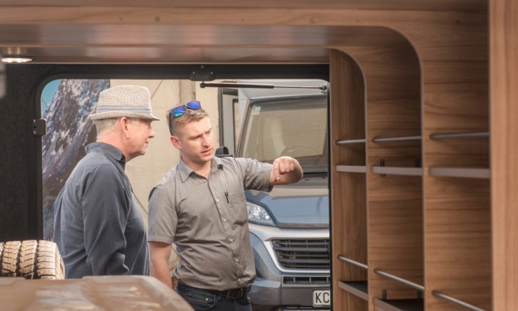 A man talking to a sales consultant about garage space of a motorhome