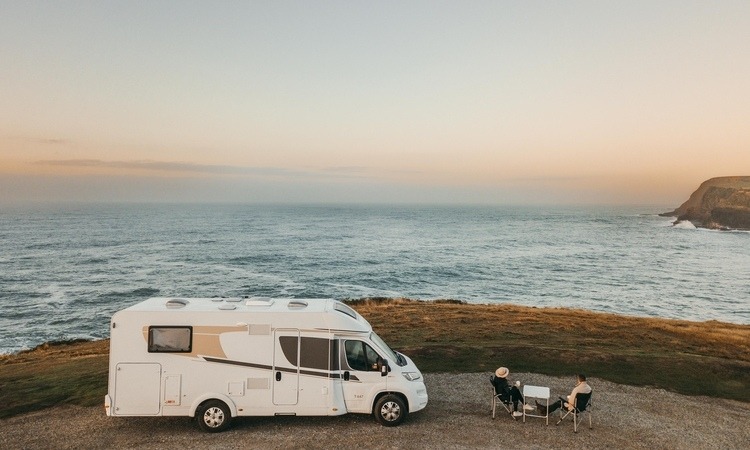 A couple relaxing at Curio Bay Catlins outside of their motorhome