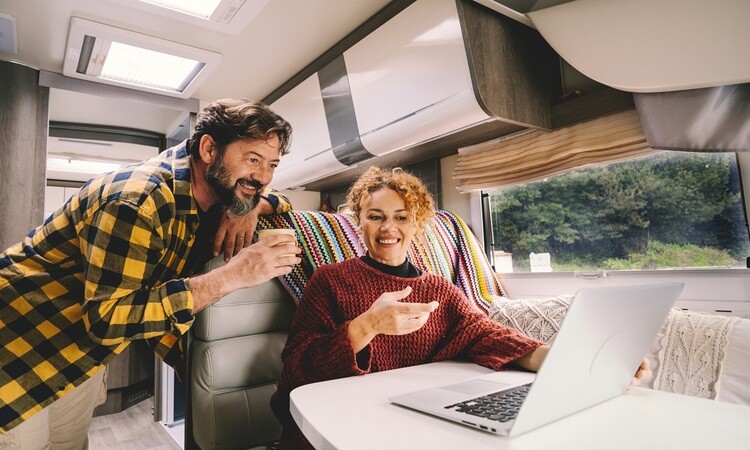 A couple looking at laptop in motorhome living area