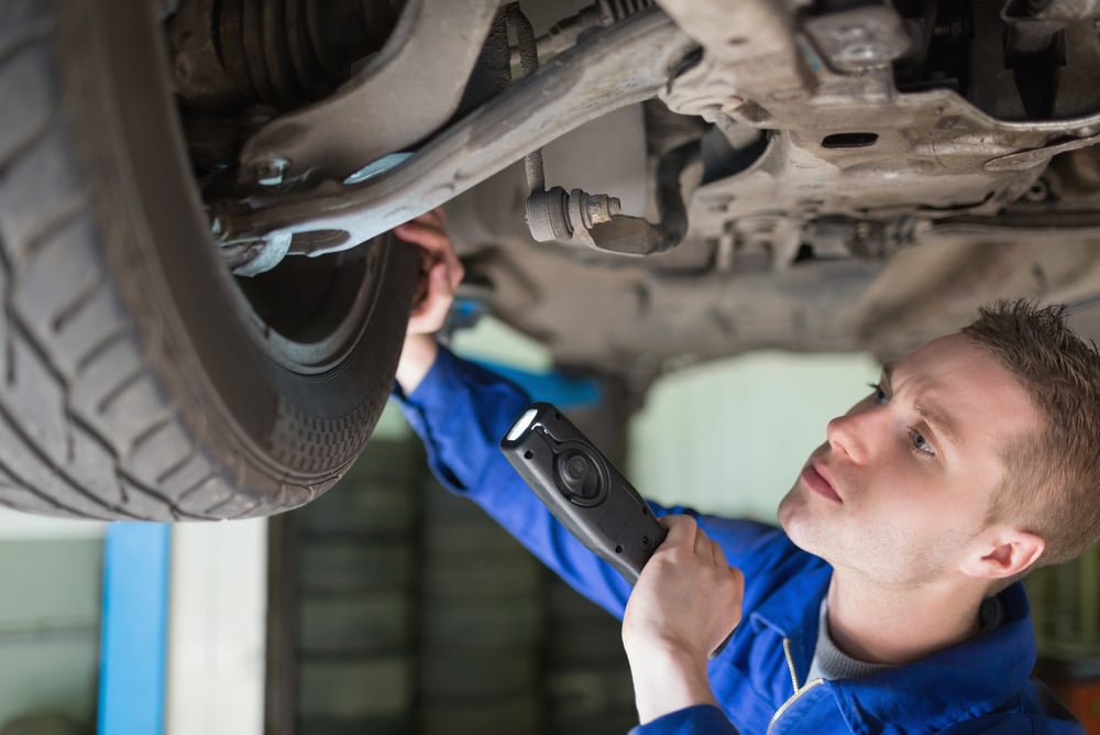 A mechanic with flashlight examining tyre