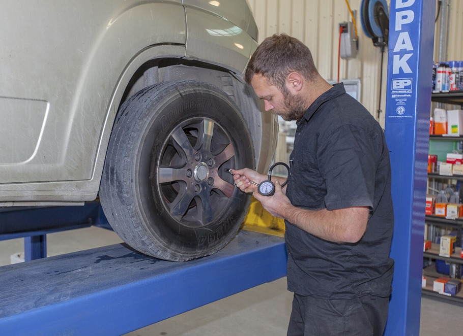 Technician checking a tyre pressure