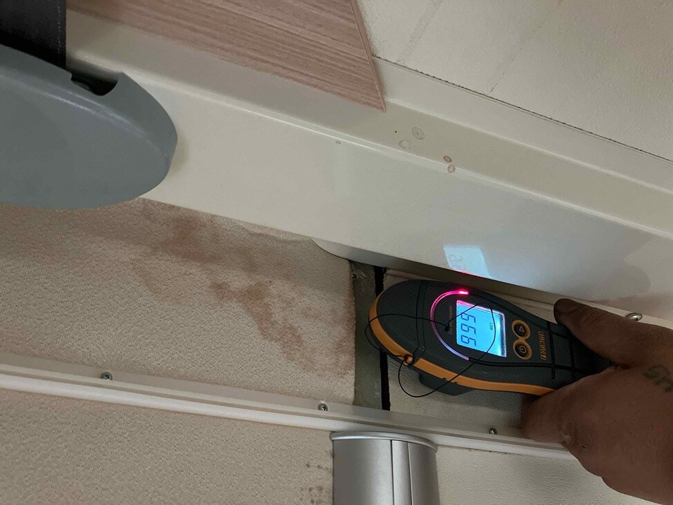 A moisture detector being used to detect water damage