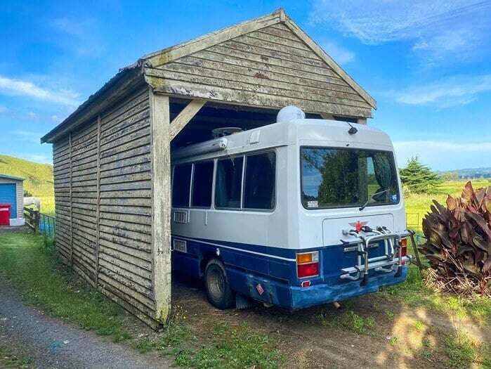 A motorhome stored in a small carport garage