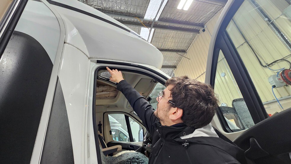 A technician inspecting the door seal of a motorhome