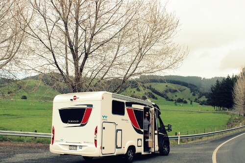 Woman exits Wilderness motorhome through door on the right